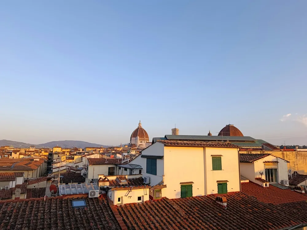The Duomo rising above Florence's terracotta rooftops at golden hour